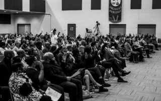LIVE FREE Indiana community members raising their hands during a public gathering
